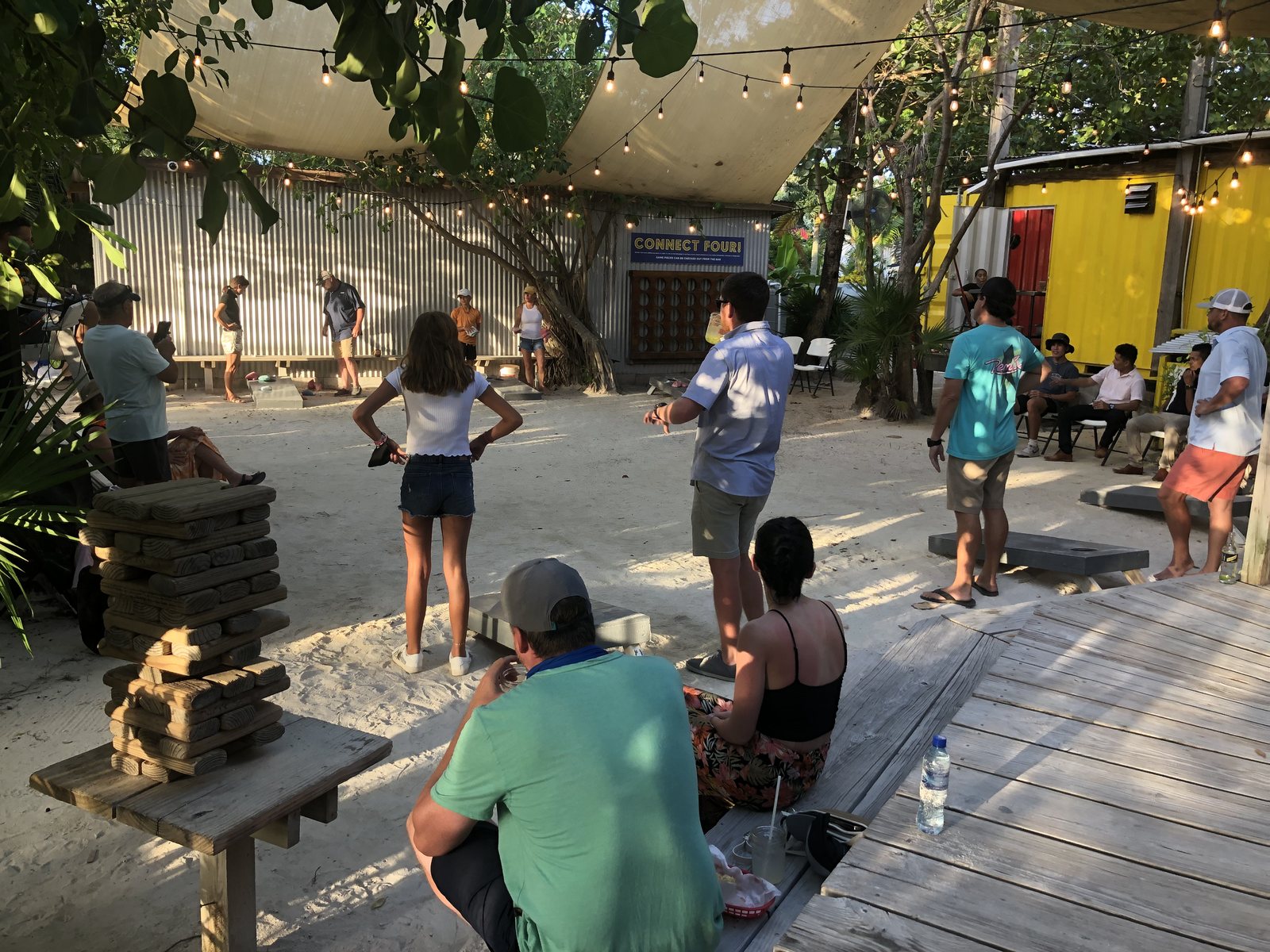 The open-air courtyard at dusk &mdash; sand underfoot, trees overhead